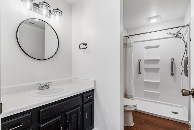 bathroom with toilet, wood finished floors, and vanity