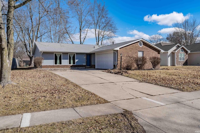 single story home featuring driveway, brick siding, and an attached garage