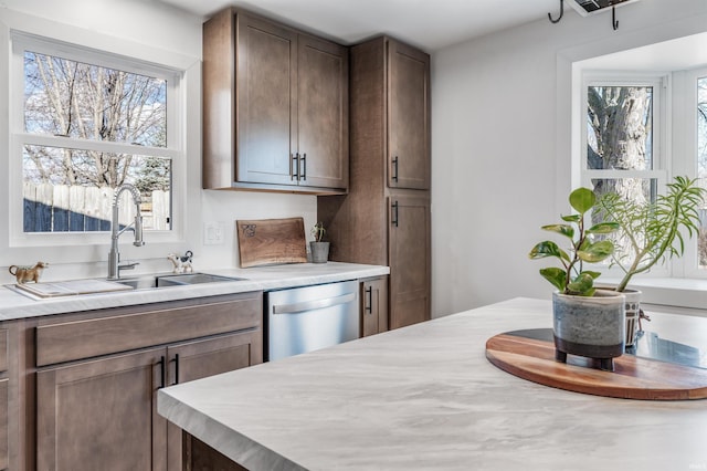 kitchen with a sink, light countertops, and dishwasher