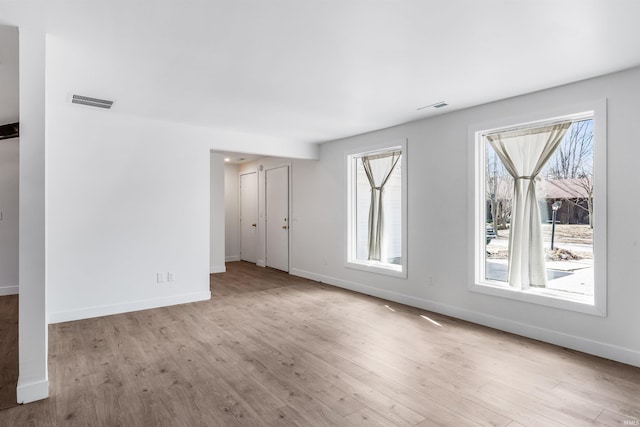 interior space with wood finished floors, visible vents, and baseboards