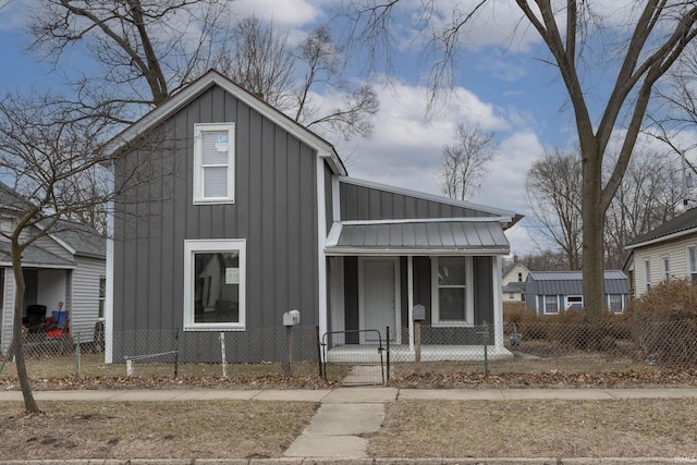 view of front of house with a fenced front yard, metal roof, a standing seam roof, a gate, and board and batten siding