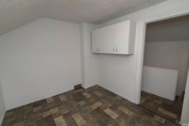 interior space featuring stone finish flooring, baseboards, and a textured ceiling