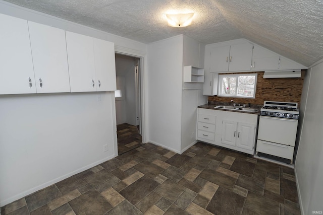 kitchen featuring under cabinet range hood, a sink, white cabinets, white gas range oven, and dark countertops