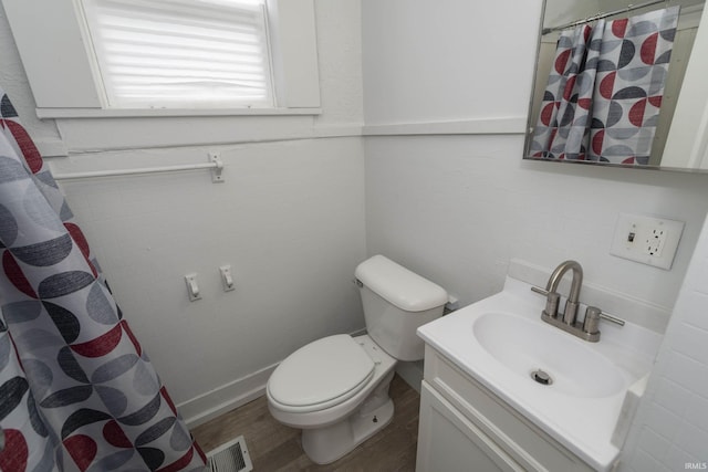 bathroom with visible vents, toilet, a shower with curtain, wood finished floors, and vanity