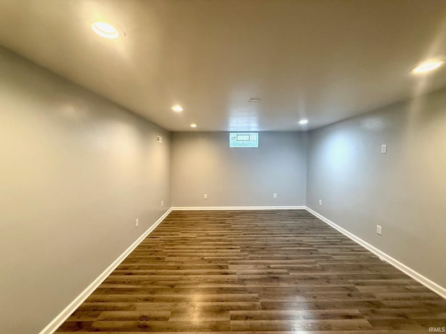 below grade area with dark wood-type flooring, recessed lighting, and baseboards