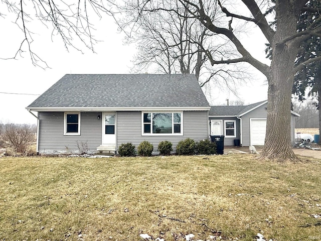 view of front of house with entry steps, a front lawn, roof with shingles, and a garage