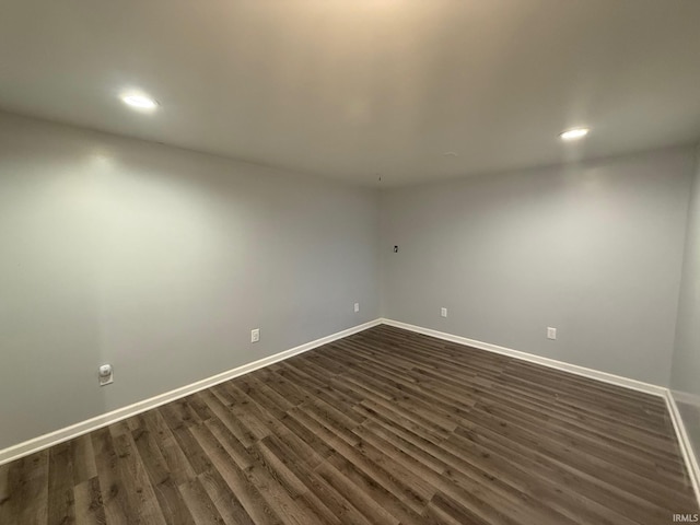 spare room featuring dark wood-style floors, baseboards, and recessed lighting