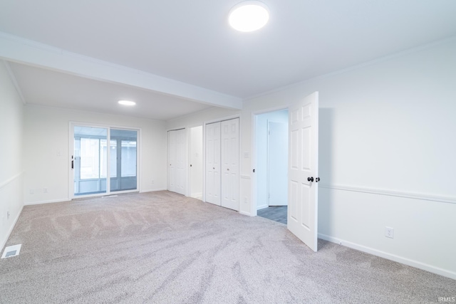 interior space with baseboards, visible vents, crown molding, and carpet flooring