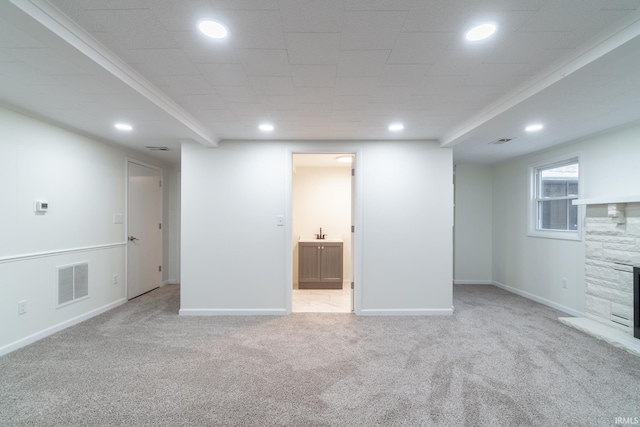 below grade area with baseboards, visible vents, carpet floors, a fireplace, and recessed lighting