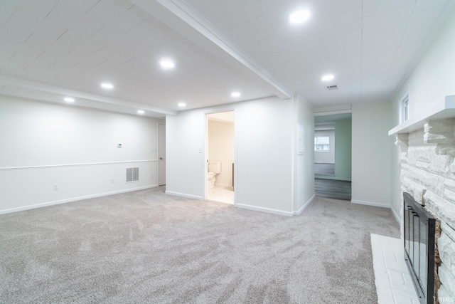 basement featuring a stone fireplace, recessed lighting, light carpet, visible vents, and baseboards