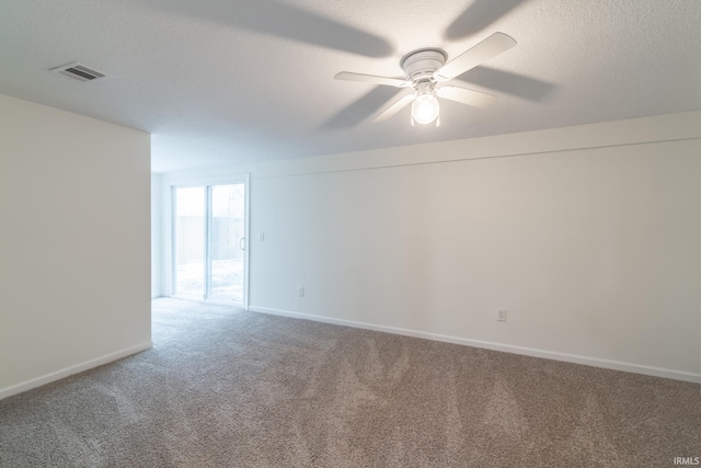 carpeted spare room featuring visible vents, ceiling fan, a textured ceiling, and baseboards