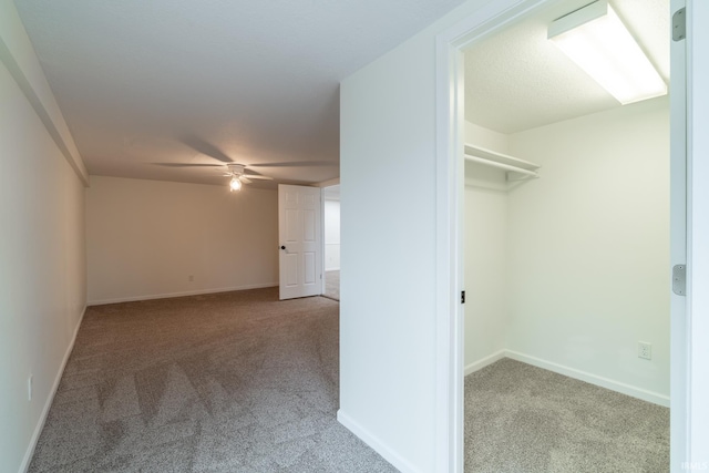 interior space with a ceiling fan and carpet