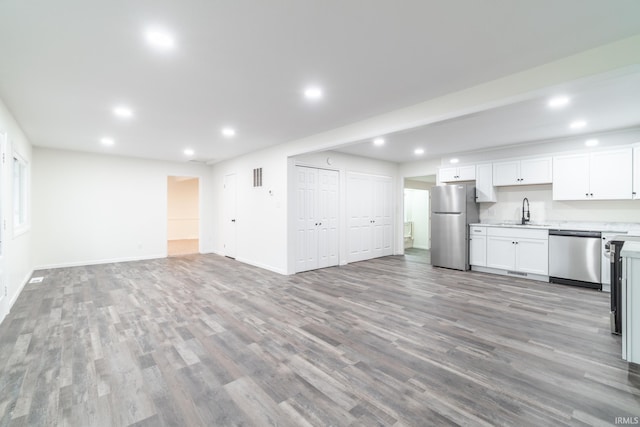 interior space featuring light countertops, light wood-style flooring, appliances with stainless steel finishes, open floor plan, and a sink