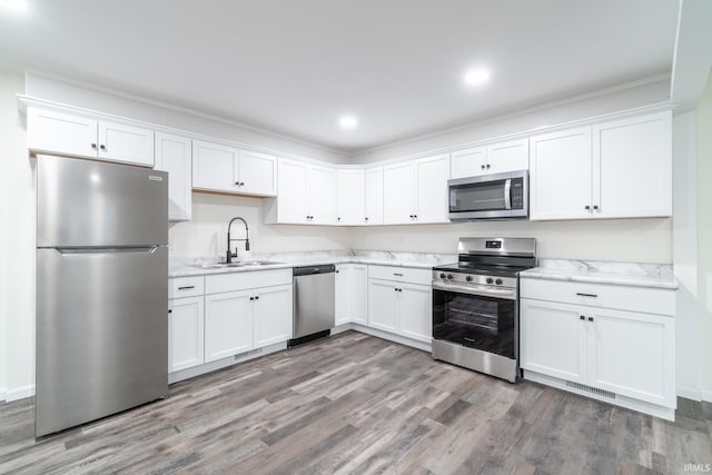 kitchen with stainless steel appliances, a sink, and white cabinetry