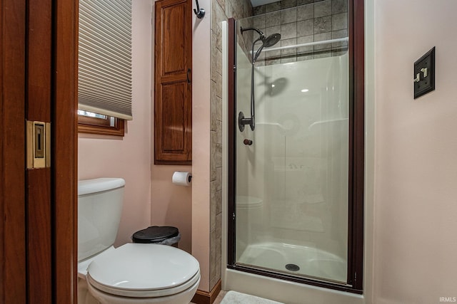 bathroom featuring toilet and a shower stall