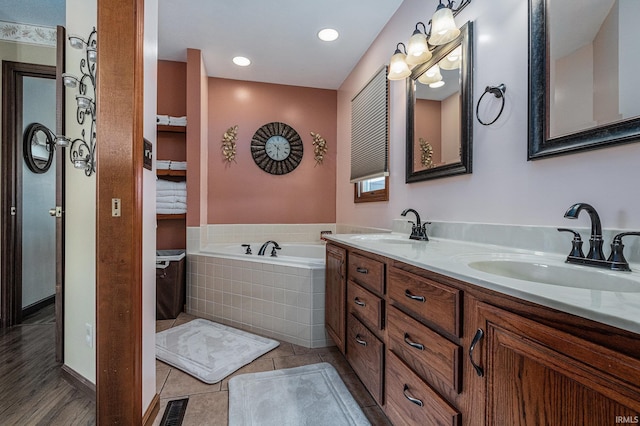 full bathroom with a bath, tile patterned flooring, a sink, and visible vents