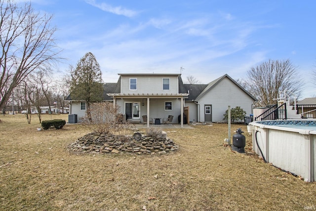 rear view of property featuring a patio, cooling unit, and an outdoor pool