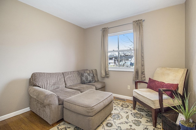 sitting room featuring light wood-style floors, visible vents, and baseboards