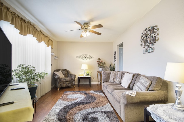 living room with wood finished floors, a ceiling fan, and baseboards