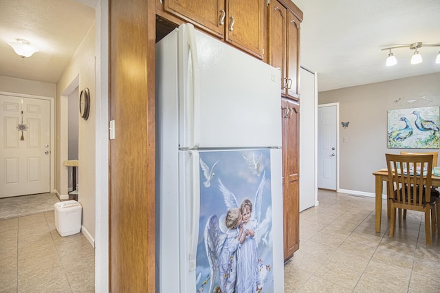 hall featuring baseboards and light tile patterned floors