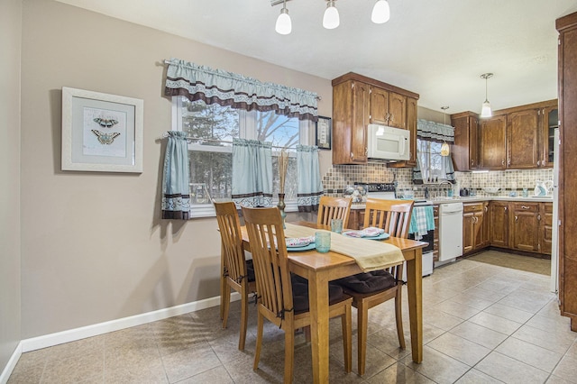 dining space featuring light tile patterned floors and baseboards