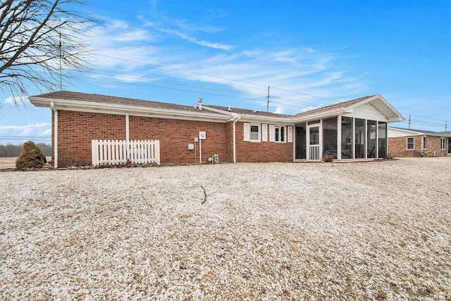 back of house with a sunroom and brick siding