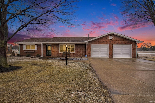 ranch-style home featuring an attached garage, a front lawn, concrete driveway, and brick siding