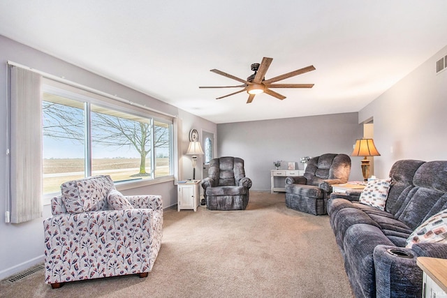 carpeted living area featuring baseboards, visible vents, and ceiling fan