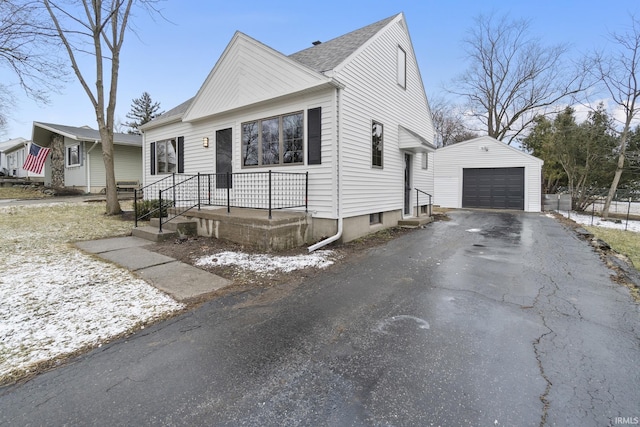 view of front of home featuring driveway, an outdoor structure, and a detached garage