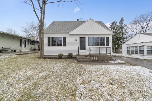 bungalow featuring roof with shingles