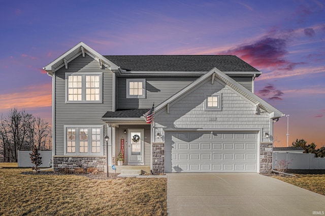 traditional home with roof with shingles, concrete driveway, an attached garage, fence, and stone siding