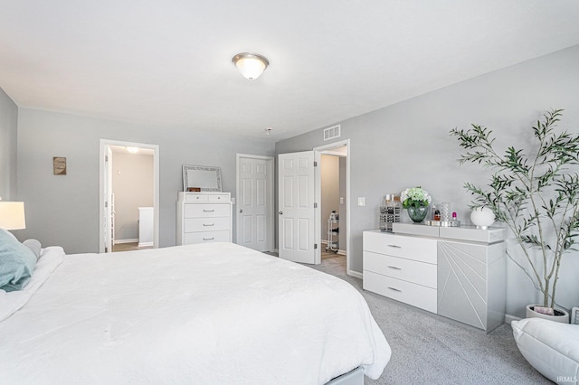 bedroom featuring light carpet, ensuite bath, and visible vents