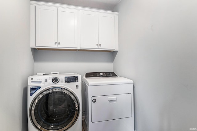 laundry area featuring washing machine and dryer and cabinet space