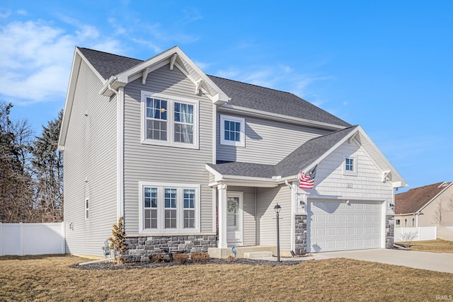 view of front facade with driveway, a garage, stone siding, fence, and a front lawn