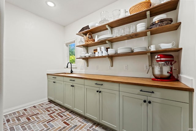 bar with brick floor, baseboards, a sink, and recessed lighting