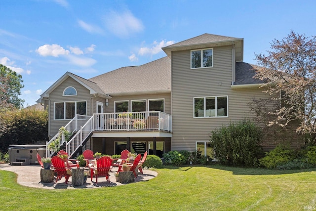 back of house with a hot tub, a wooden deck, stairs, a yard, and a patio area