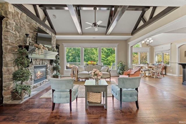 living area with wood-type flooring, high vaulted ceiling, and a stone fireplace