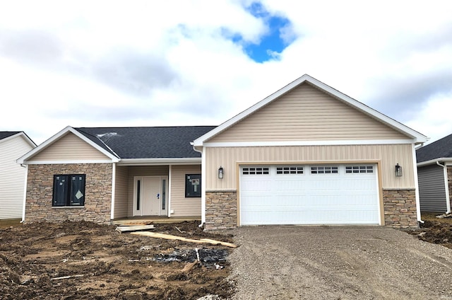 view of front of property with stone siding, board and batten siding, an attached garage, and driveway