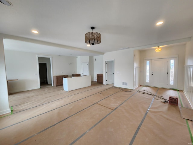 unfurnished living room featuring baseboards, visible vents, and recessed lighting