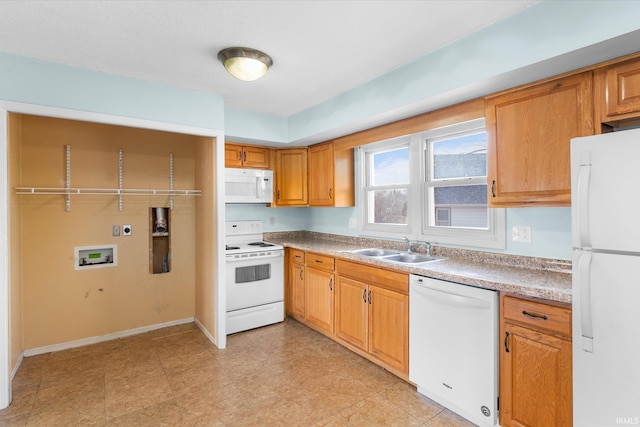 kitchen featuring light countertops, white appliances, and a sink