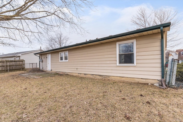 rear view of property with fence and a yard