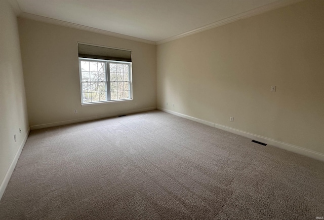 empty room with carpet floors, ornamental molding, visible vents, and baseboards