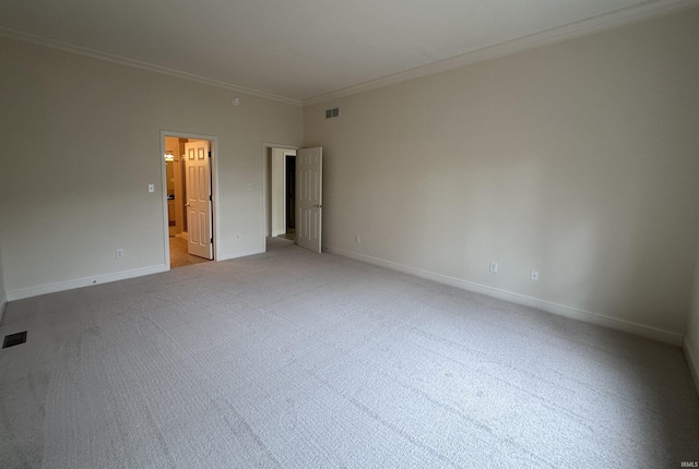 empty room featuring light carpet, crown molding, visible vents, and baseboards