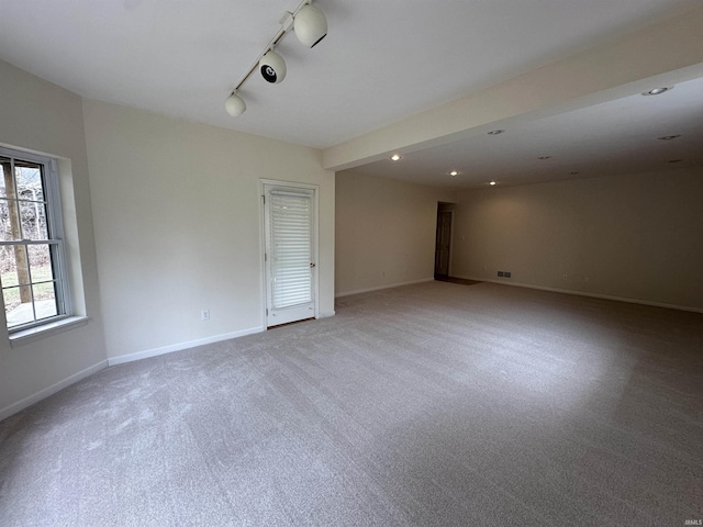 empty room featuring light carpet, visible vents, baseboards, track lighting, and recessed lighting