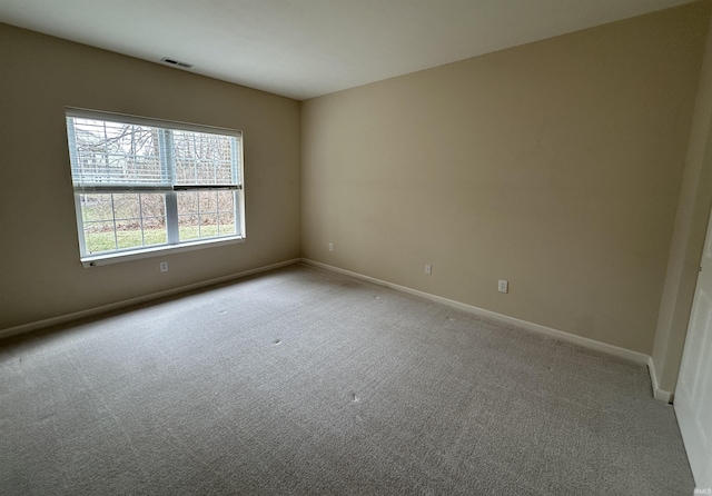 carpeted empty room featuring visible vents and baseboards