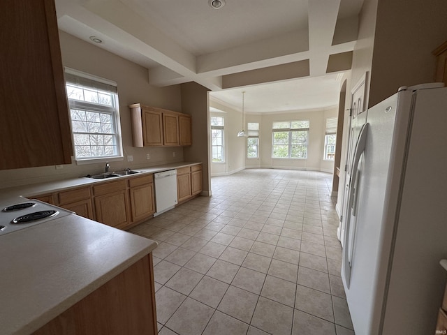 kitchen featuring white appliances, light tile patterned floors, baseboards, light countertops, and a sink