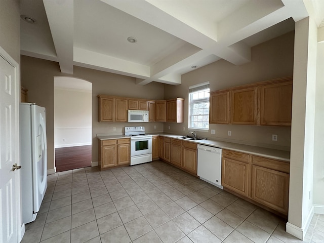 kitchen with white appliances, baseboards, light countertops, and a sink