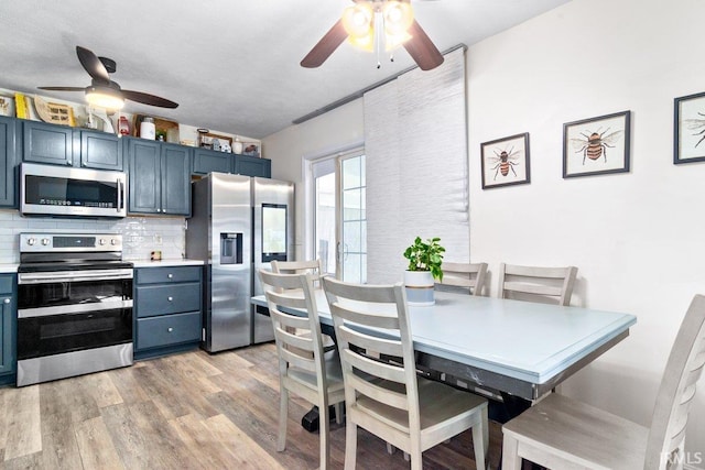 dining area with light wood-style flooring and a ceiling fan