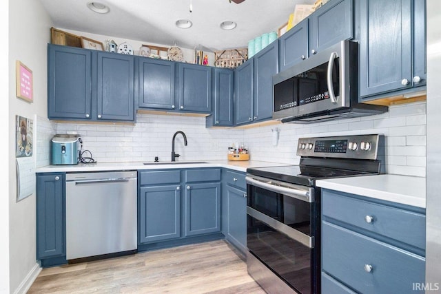 kitchen with a sink, light countertops, blue cabinets, and stainless steel appliances