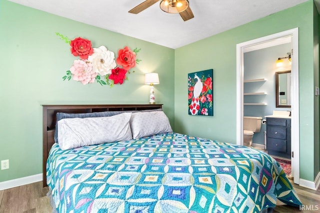 bedroom featuring wood finished floors, baseboards, ensuite bathroom, and ceiling fan